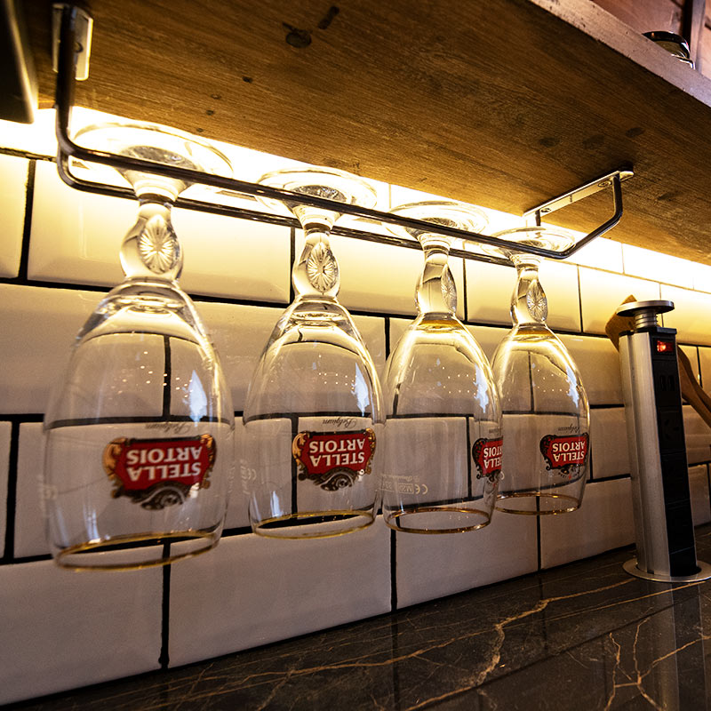Detalle social con copas y luces cálidas en KitchBox